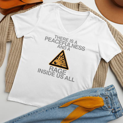 "There is a peacefulness and a rage inside us all" printed on a solid white blend women's relaxed v-neck t-shirt laying on a flat surface amongst other clothes