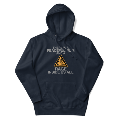 "There is a peacefulness and a rage inside us all" printed on a navy blazer unisex hoodie laying on a flat surface with the hood up