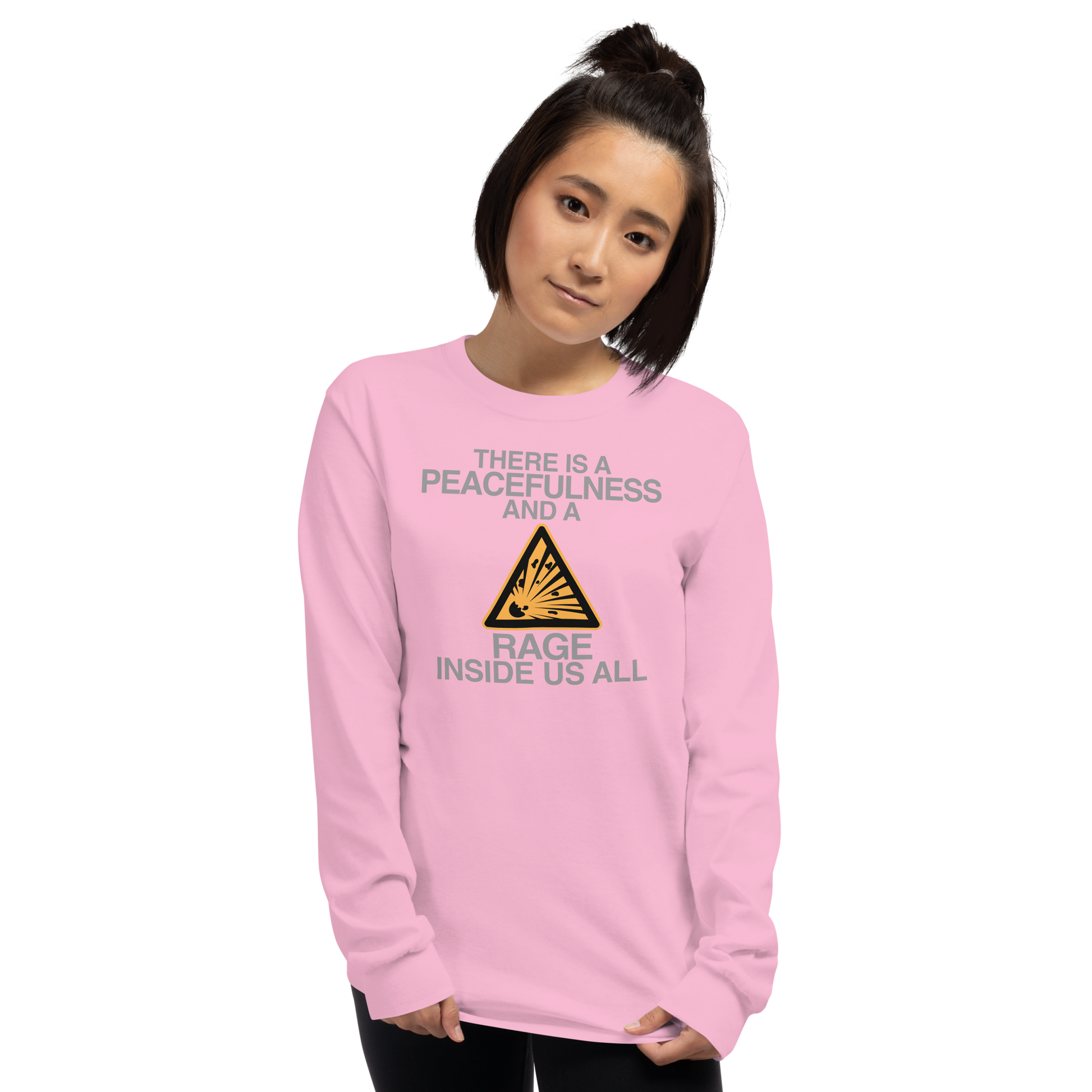 "There is a peacefulness and a rage inside us all" printed on a light pink men's long sleeve shirt worn by a female
