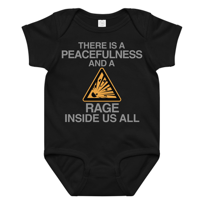 "There is a peacefulness and a rage inside us all" printed on a black baby jersey bodysuit laying on a flat surface amongst other clothes