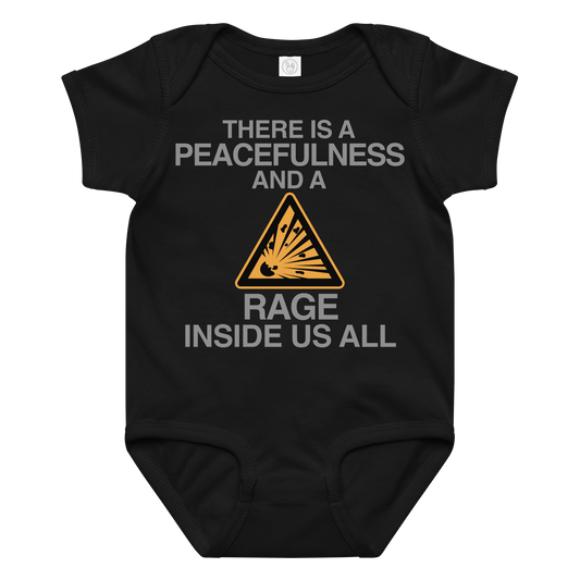 "There is a peacefulness and a rage inside us all" printed on a black baby jersey bodysuit laying on a flat surface amongst other clothes