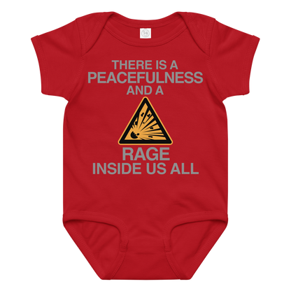 "There is a peacefulness and a rage inside us all" printed on a red baby jersey bodysuit laying on a flat surface amongst other clothes