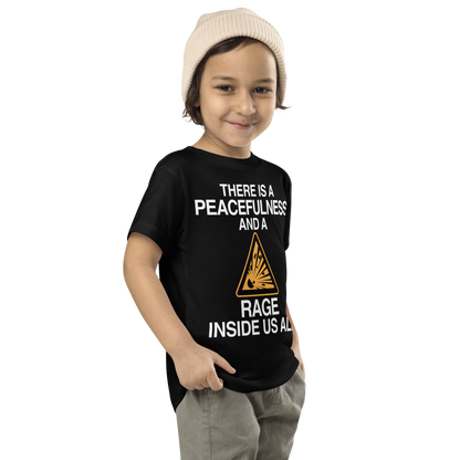"There is a peacefulness and a rage inside us all" printed on a black toddler short sleeve tee worn by a male who is also wearing a knit cap
