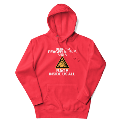 "There is a peacefulness and a rage inside us all" printed on a team red unisex hoodie laying on a flat surface with the hood up