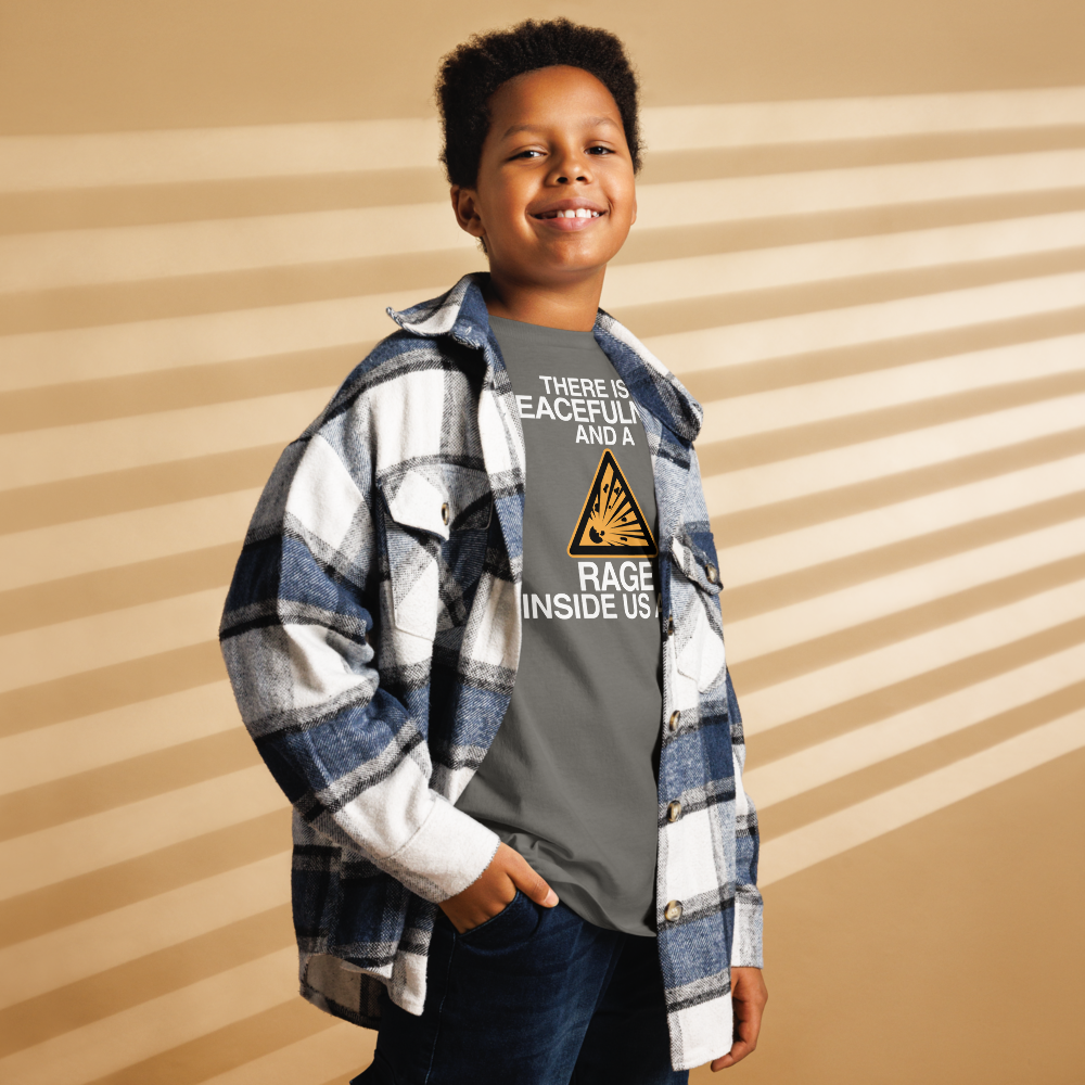 "There is a peacefulness and a rage inside us all" printed on a charcoal youth classic tee worn by a male also wearing a jacket