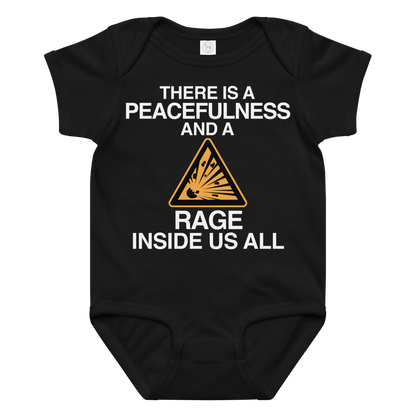 "There is a peacefulness and a rage inside us all" printed on a black baby jersey bodysuit laying on a flat surface amongst other clothes