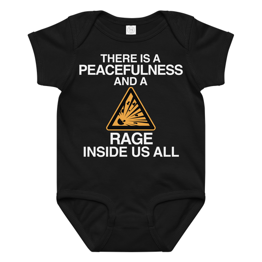 "There is a peacefulness and a rage inside us all" printed on a black baby jersey bodysuit laying on a flat surface amongst other clothes