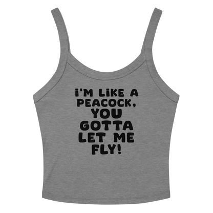 "I'm like a peacock, you gotta let me fly!" printed on a athletic heather women's micro-rib tanktop laying on a flat surface amongst sunglasses and shorts