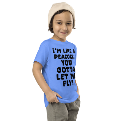 "I'm like a peacock, you gotta let me fly!" printed on a heather columbia blue toddler short sleeve tee worn by a male who is also wearing a knit cap