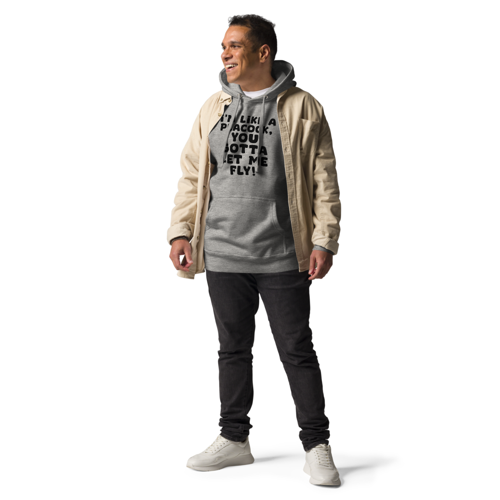 "I'm like a peacock, you gotta let me fly!" printed on a carbon grey unisex hoodie worn by a male with a jacket on top