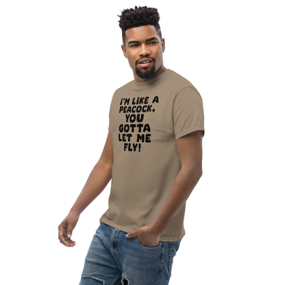 "I'm like a peacock, you gotta let me fly!" printed on a brown savana unisex classic tee worn by a male