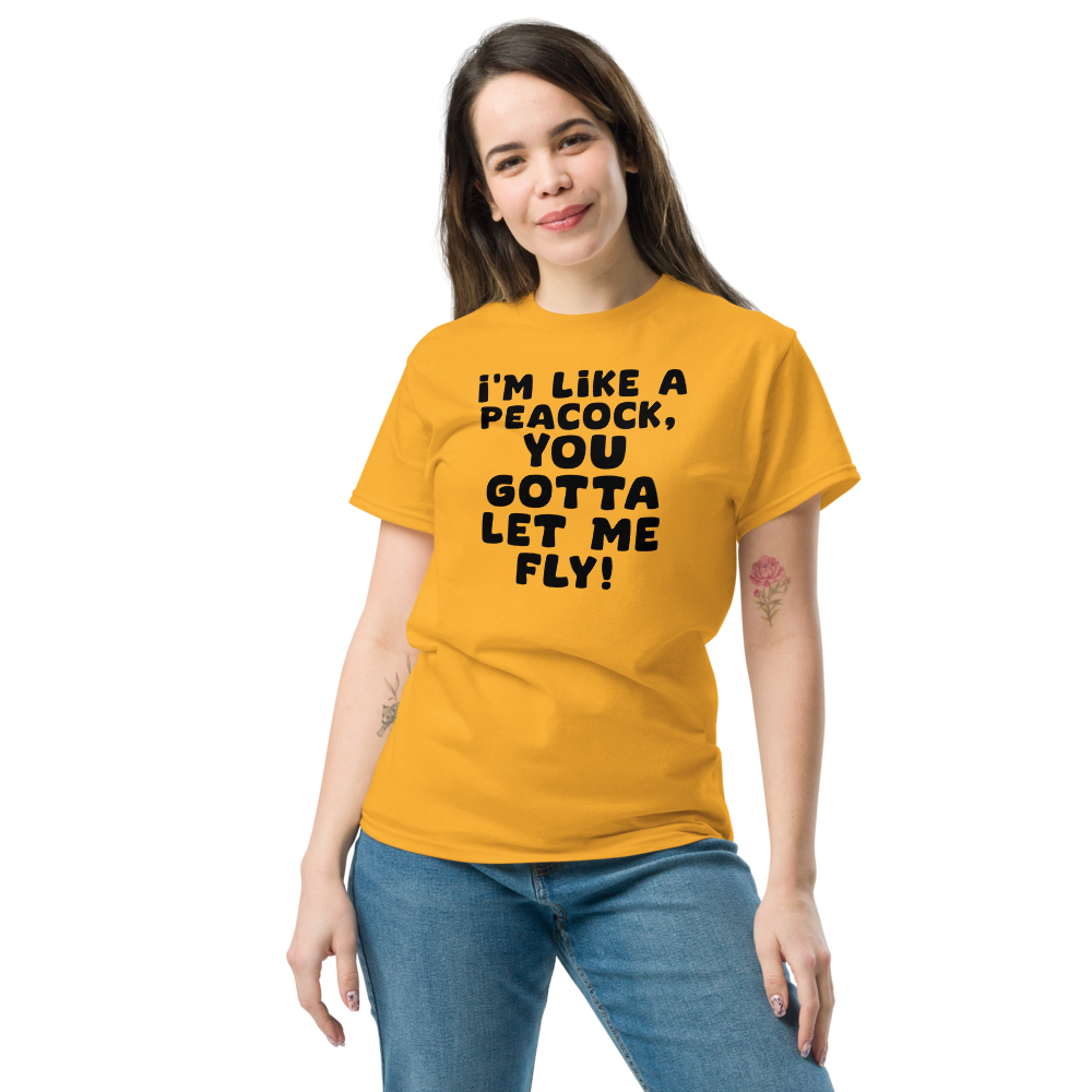 "I'm like a peacock, you gotta let me fly!" printed on a gold unisex classic tee worn by a female