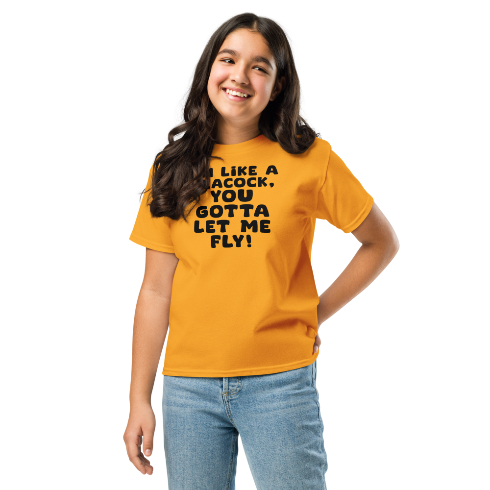 "I'm like a peacock, you gotta let me fly!" printed on a gold youth classic tee worn by a female