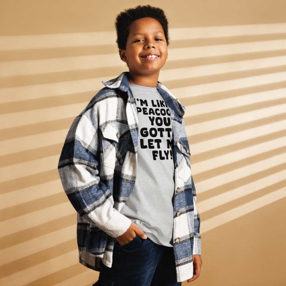 "I'm like a peacock, you gotta let me fly!" printed on a sport grey youth classic tee worn by a male also wearing a jacket