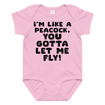 "I'm like a peacock, you gotta let me fly!" printed on a pink baby jersey bodysuit laying on a flat surface amongst other clothes