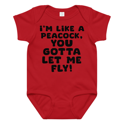 "I'm like a peacock, you gotta let me fly!" printed on a red baby jersey bodysuit laying on a flat surface amongst other clothes