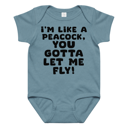 "I'm like a peacock, you gotta let me fly!" printed on a vintage indigo baby jersey bodysuit laying on a flat surface amongst other clothes