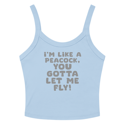 "I'm like a peacock, you gotta let me fly!" printed on a solid baby blue blend women's micro-rib tanktop laying on a flat surface amongst sunglasses and shorts