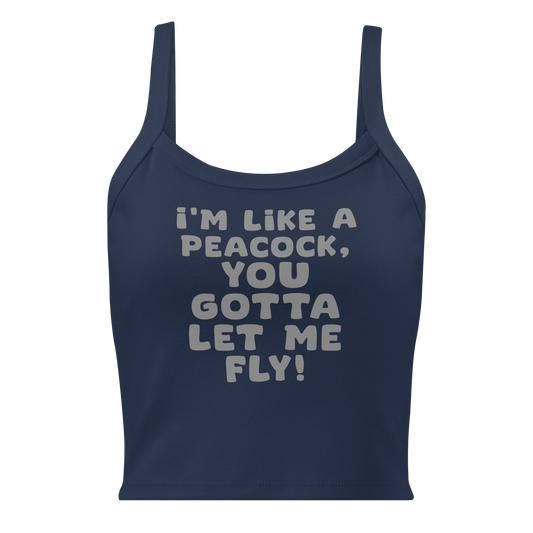 "I'm like a peacock, you gotta let me fly!" printed on a solid navy blend women's micro-rib tanktop laying on a flat surface