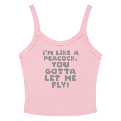 "I'm like a peacock, you gotta let me fly!" printed on a solid pink blend women's micro-rib tanktop laying on a flat surface amongst sunglasses and shorts