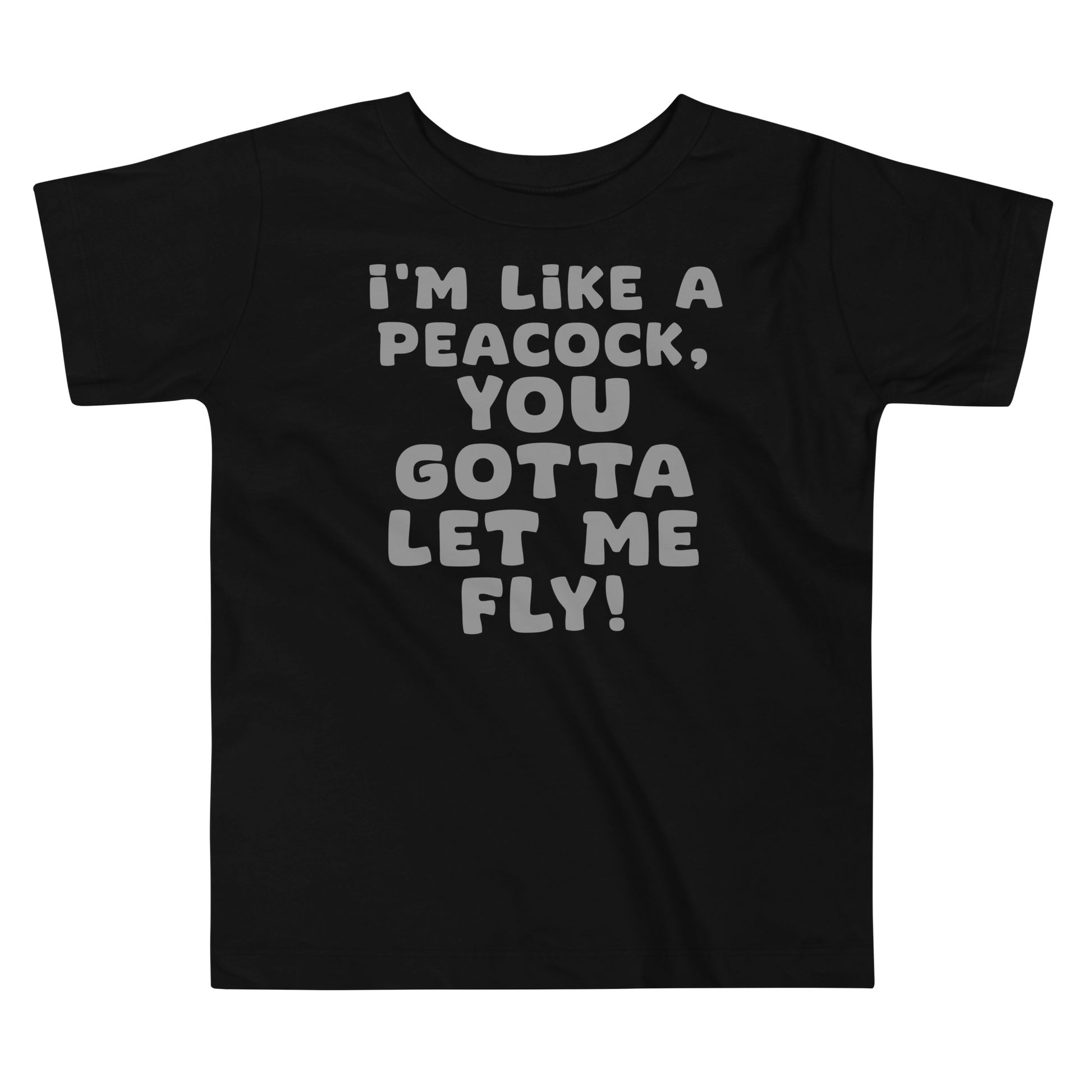 "I'm like a peacock, you gotta let me fly!" printed on a black toddler short sleeve tee laying on a flat surface