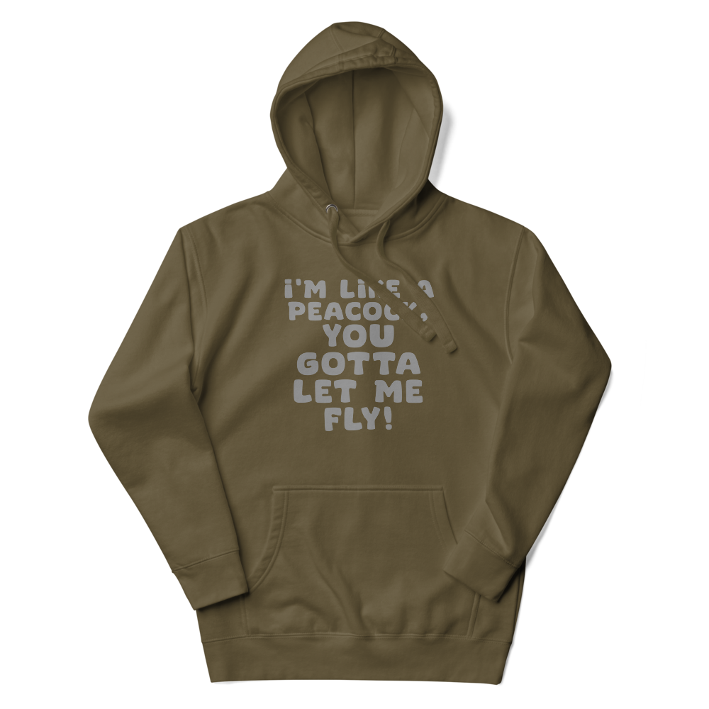 "I'm like a peacock, you gotta let me fly!" printed on a military green unisex hoodie laying on a flat surface with the hood up