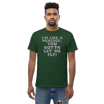 "I'm like a peacock, you gotta let me fly!" printed on a forest green unisex classic tee worn by a male