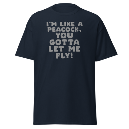 "I'm like a peacock, you gotta let me fly!" printed on a navy unisex classic tee laying on a flat surface