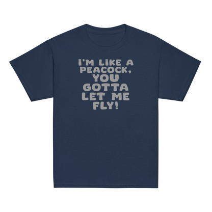 "I'm like a peacock, you gotta let me fly!" printed on a navy youth classic tee laying on a flat surface