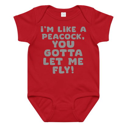 "I'm like a peacock, you gotta let me fly!" printed on a red baby jersey bodysuit laying on a flat surface amongst other clothes