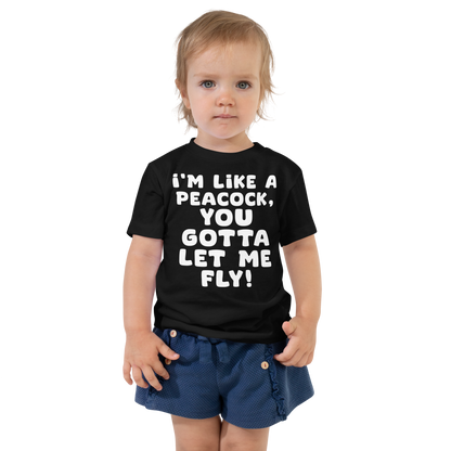 "I'm like a peacock, you gotta let me fly!" printed on a black toddler short sleeve tee worn by a female