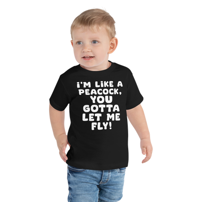 "I'm like a peacock, you gotta let me fly!" printed on a black toddler short sleeve tee worn by a male