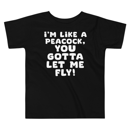 "I'm like a peacock, you gotta let me fly!" printed on a black toddler short sleeve tee laying on a flat surface