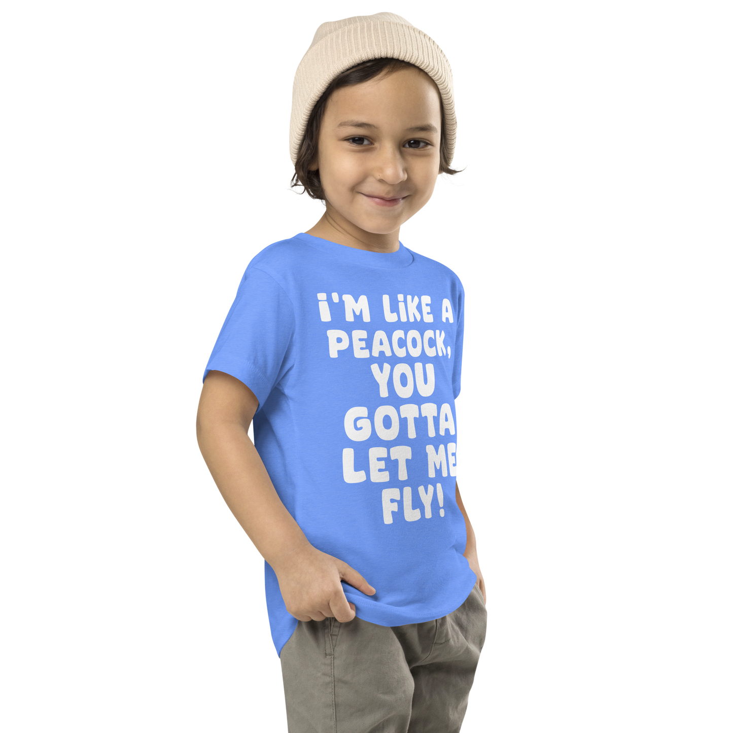 "I'm like a peacock, you gotta let me fly!" printed on a heather columbia blue toddler short sleeve tee worn by a male who is also wearing a knit cap