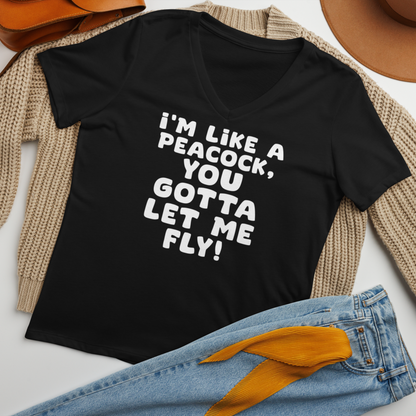 "I'm like a peacock, you gotta let me fly!" printed on a solid black blend women's relaxed v-neck t-shirt laying on a flat surface amongst other clothes