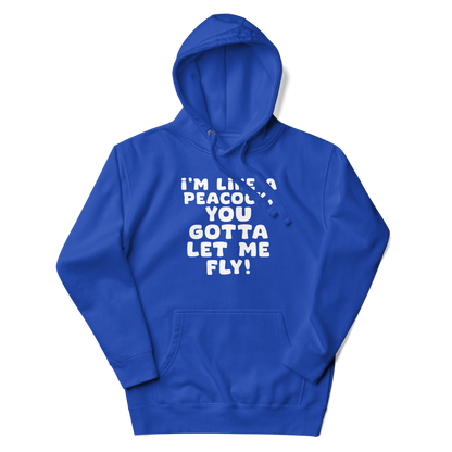 "I'm like a peacock, you gotta let me fly!" printed on a team royal unisex hoodie laying on a flat surface with the hood up