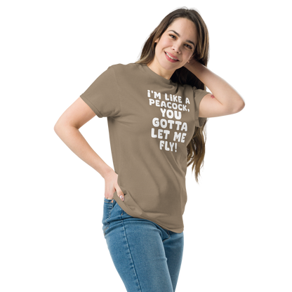 "I'm like a peacock, you gotta let me fly!" printed on a brown savana unisex classic tee worn by a female