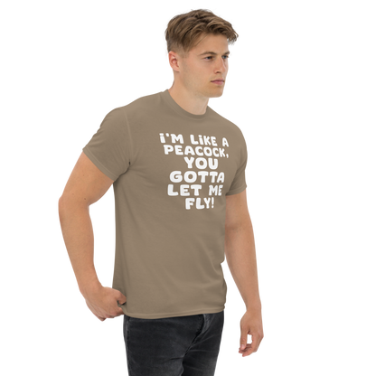 "I'm like a peacock, you gotta let me fly!" printed on a brown savana unisex classic tee worn by a male