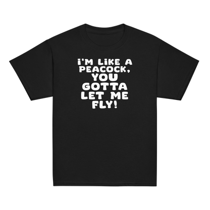 "I'm like a peacock, you gotta let me fly!" printed on a black youth classic tee laying on a flat surface