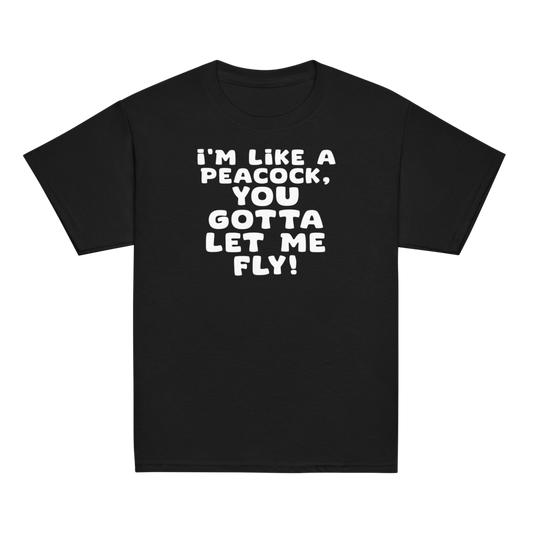 "I'm like a peacock, you gotta let me fly!" printed on a black youth classic tee laying on a flat surface