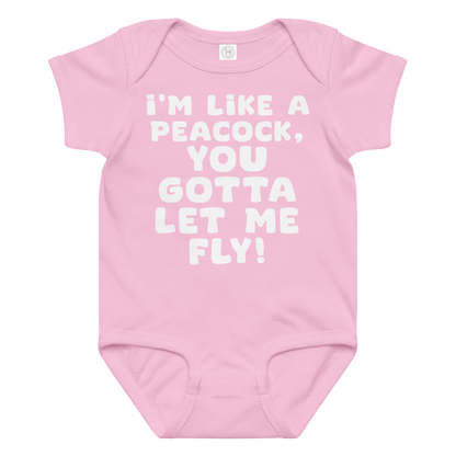 "I'm like a peacock, you gotta let me fly!" printed on a pink baby jersey bodysuit laying on a flat surface amongst other clothes