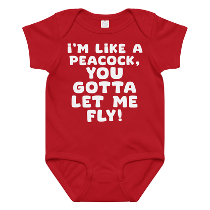 "I'm like a peacock, you gotta let me fly!" printed on a red baby jersey bodysuit laying on a flat surface amongst other clothes