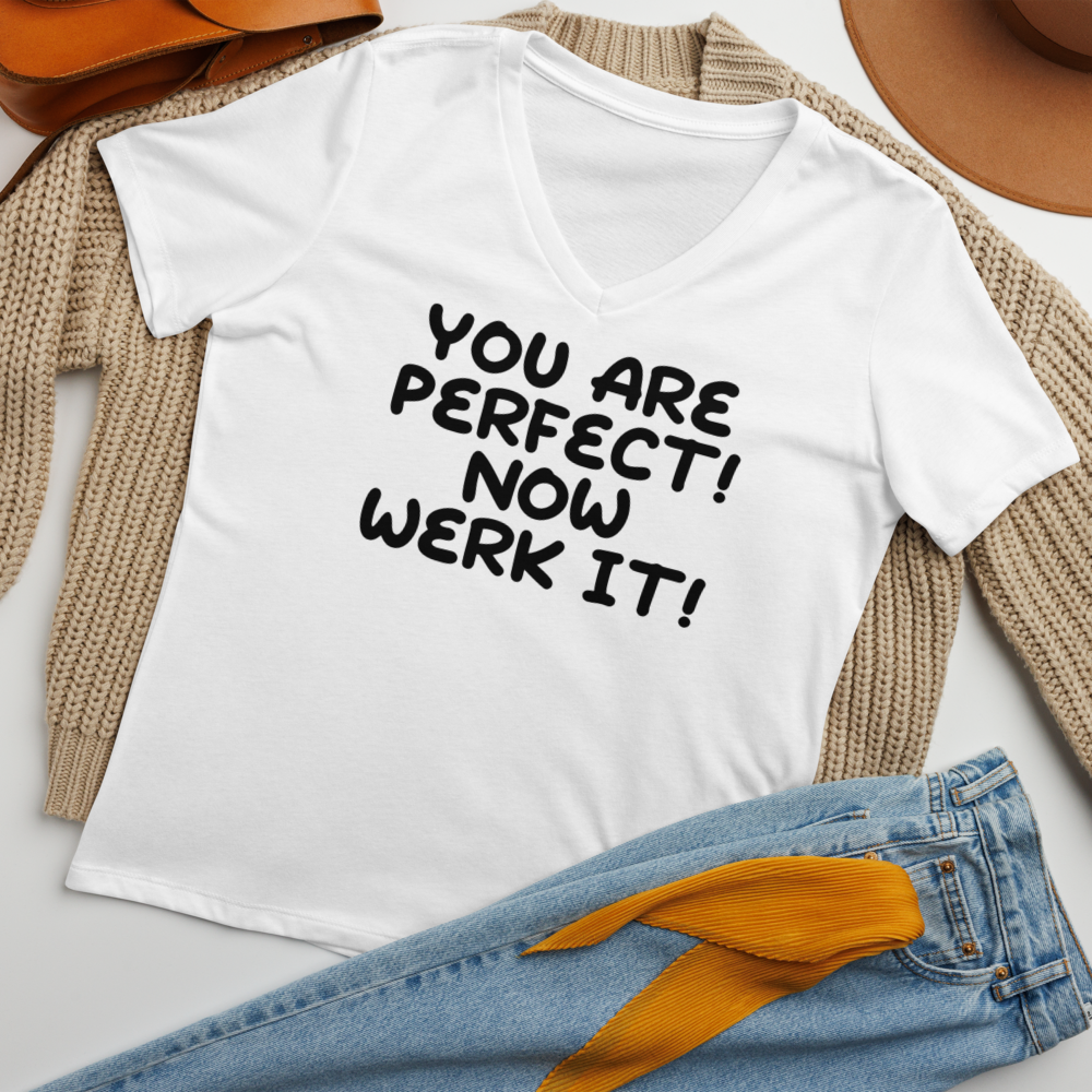 "You Are Perfect! Now Werk It!" printed on a solid white blend women's relaxed v-neck t-shirt laying on a flat surface amongst other clothes