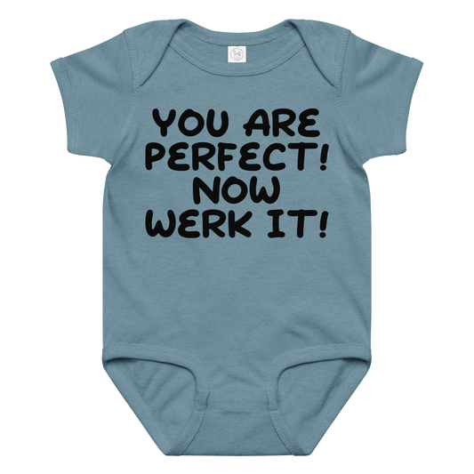 "You Are Perfect! Now Werk It!" printed on a vintage indigo baby jersey bodysuit laying on a flat surface amongst other clothes