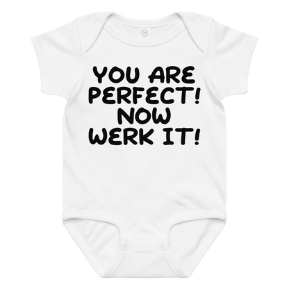 "You Are Perfect! Now Werk It!" printed on a white baby jersey bodysuit laying on a flat surface amongst other clothes