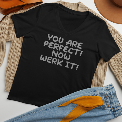 "You Are Perfect! Now Werk It!" printed on a solid black blend women's relaxed v-neck t-shirt laying on a flat surface amongst other clothes