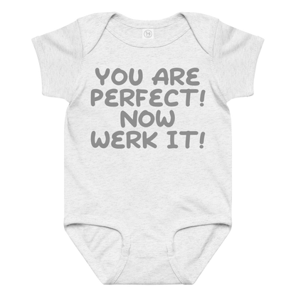 "You Are Perfect! Now Werk It!" printed on a ash baby jersey bodysuit laying on a flat surface amongst other clothes