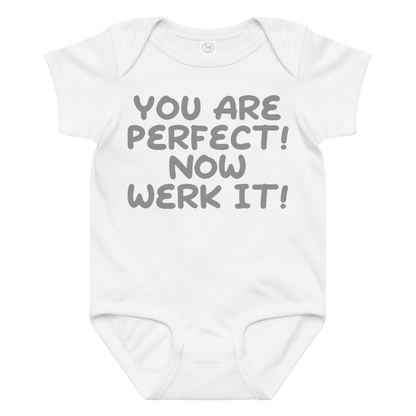 "You Are Perfect! Now Werk It!" printed on a white baby jersey bodysuit laying on a flat surface amongst other clothes