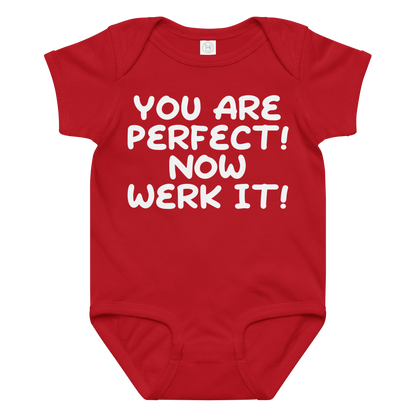 "You Are Perfect! Now Werk It!" printed on a red baby jersey bodysuit laying on a flat surface amongst other clothes