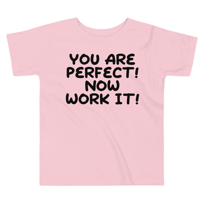 "You Are Perfect! Now Work It!" printed on a pink toddler short sleeve tee laying on a flat surface
